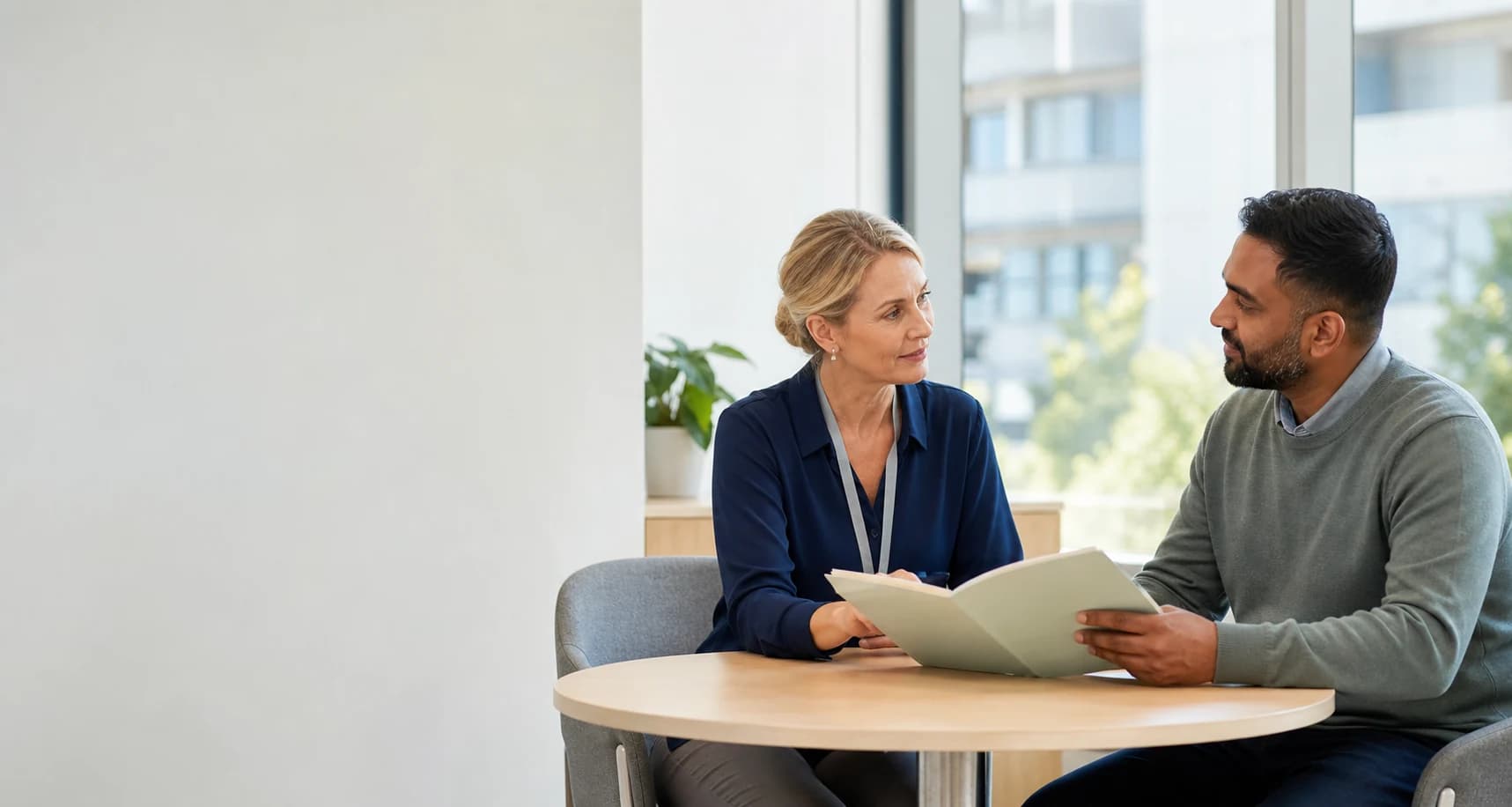 A healthcare professional and disability support coordinator discussing a hospital discharge referral