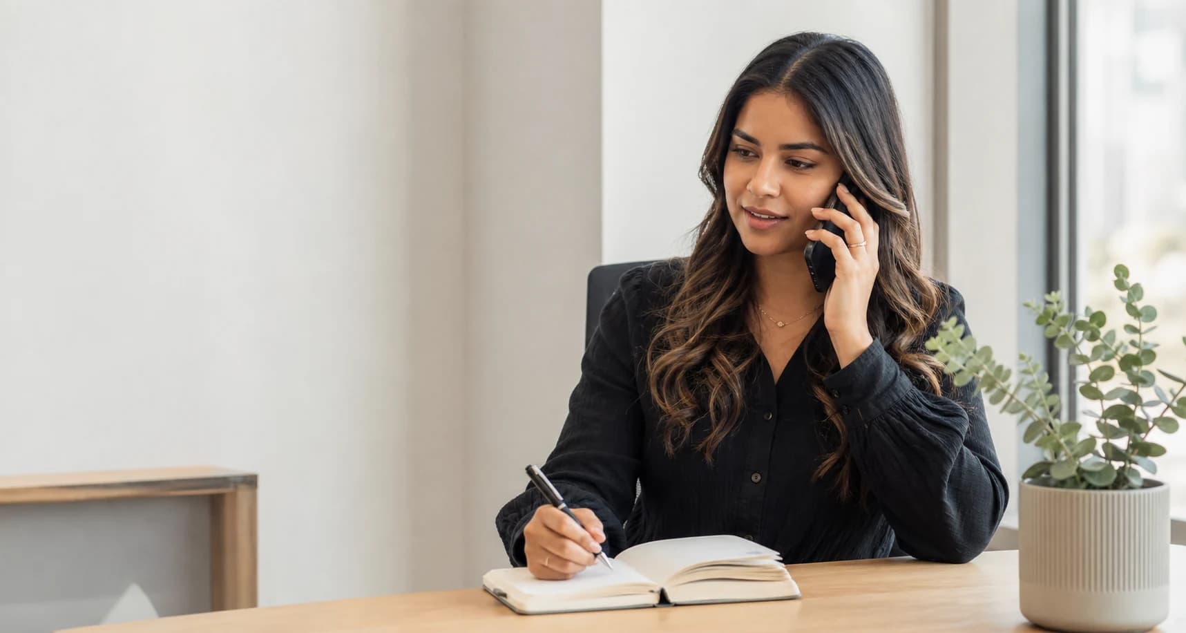 A PrimeEdge Aravia team member responding to a telephone enquiry in a modern office