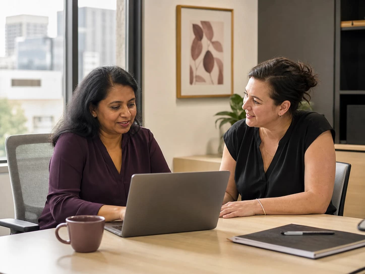 A Support Coordinator and disability support professional reviewing information together in a modern office